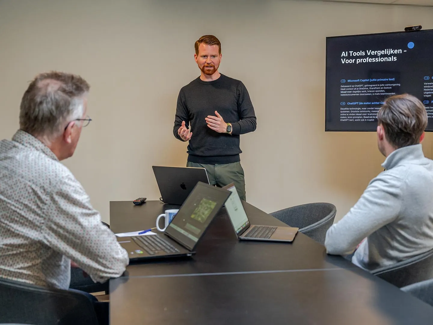 Peter geeft uitleg over AI-tools tijdens een werksessie met twee deelnemers
